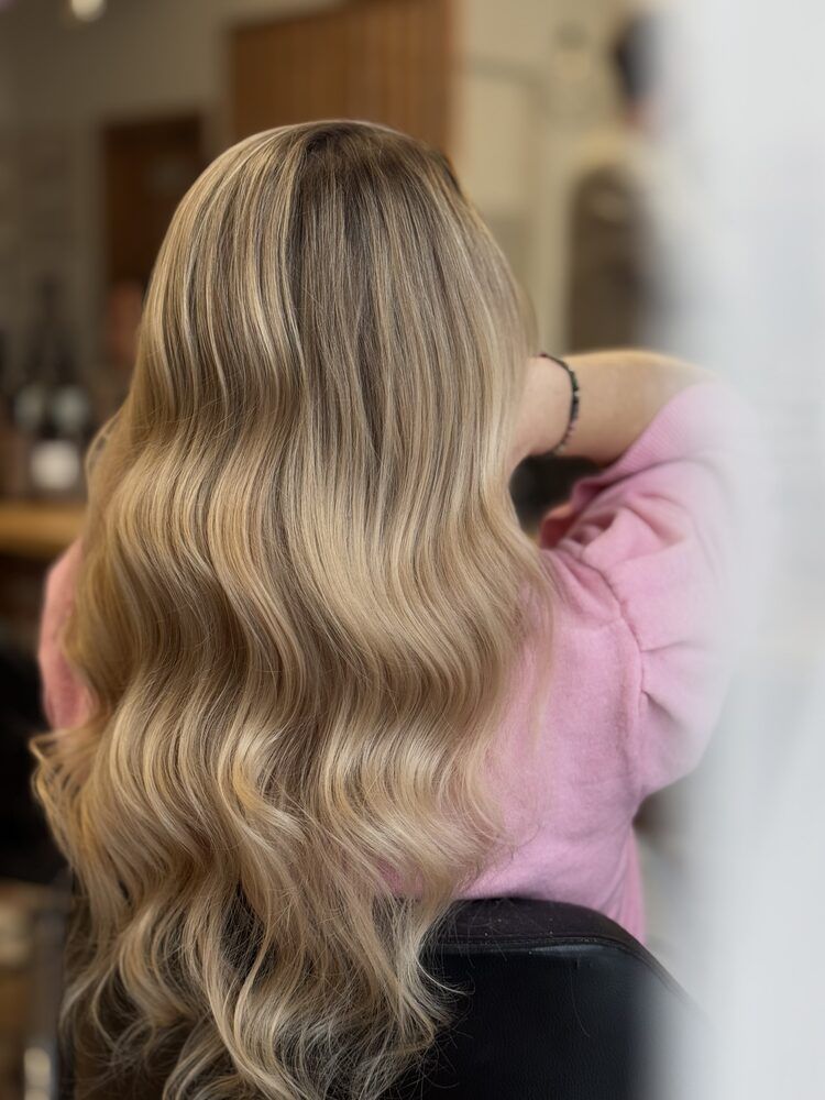 Długie blond włosy ułożone w miękkie fale w stylu hollywoodzkim